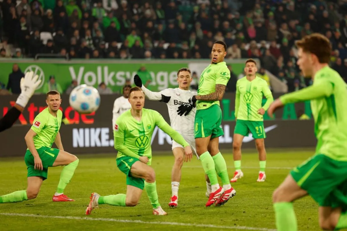 Players follow the ball from Bayer Leverkusen's German midfielder #10 Florian Wirtz (C) shot which when wide during the German first division Bundesliga football match between VfL Wolfsburg and Bayer 04 Leverkusen in Wolfsburg, northern Germany on February 8, 2025.  Odd ANDERSEN / AFP