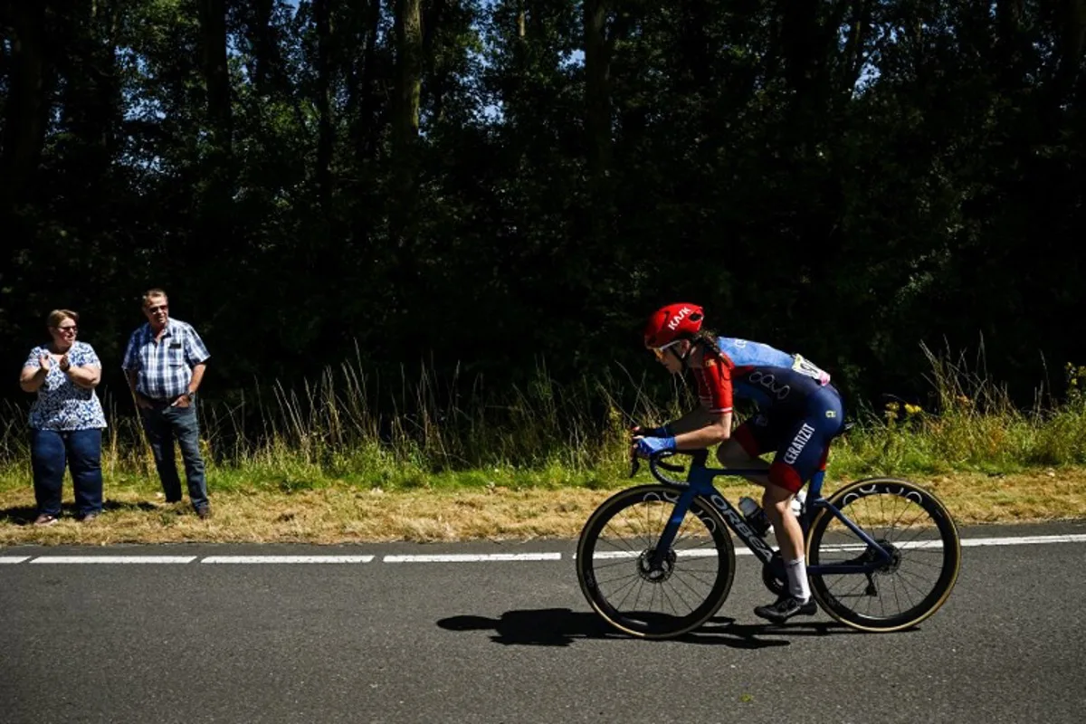 A couple watch the Ceratizit - WNT Pro Cycling Team's Polish rider Marta Lach compete during the 1st stage (out of 8) of the third edition of the Women's Tour de France cycling race, 123 km from Rotterdam to La Haye, in Netherlands, on August 12, 2024.  JULIEN DE ROSA / AFP