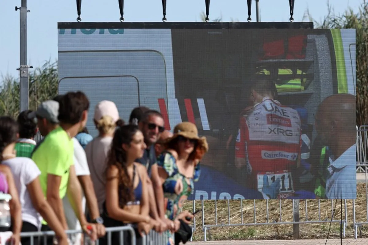 Team UAE's Slovenian rider Tadej Pogacar is seen entering an ambulance after crashing on a giant screen in the finish area of the Vuelta a Espana 2026, a 171 km race between Pucol and Xeraco on August 29, 2026. Race leader Tadej Pogacar pulled out of the Vuelta a Espana on Saturday after a heavy fall 31km from the finish of a flat stage eight left him with shoulder and face injuries. Pogacar of Team UAE has won five Tour de France titles and a Giro d'Italia and was targeting his first overall victory on the Spanish 21-day race. Josep LAGO / AFP