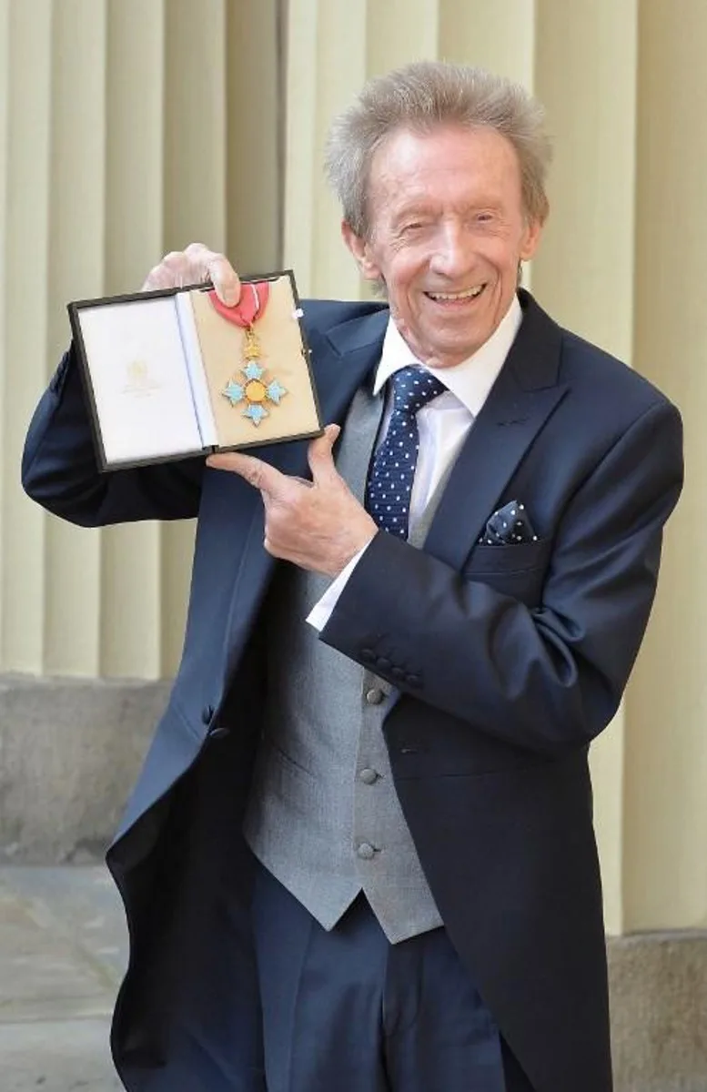 Former Scotland and Manchester United football player Denis Law holds his Commander of the Order of the British Empire (CBE) medal after an investiture ceremony in Buckingham Palace, London on March 11, 2016.   John Stillwell / POOL / AFP