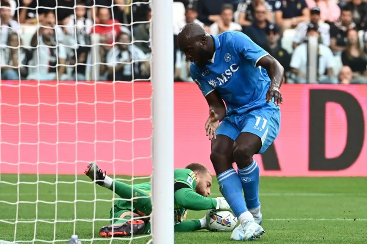 Juventus' Italian goalkeeper #29 Michele Di Gregorio stops the ball past Napoli's Belgian forward #11 Romelu Lukaku (R) during an Italian Serie A football match between Juventus and Napoli at the Allianz Stadium in Turin, on September 21, 2024.  Isabella BONOTTO / AFP