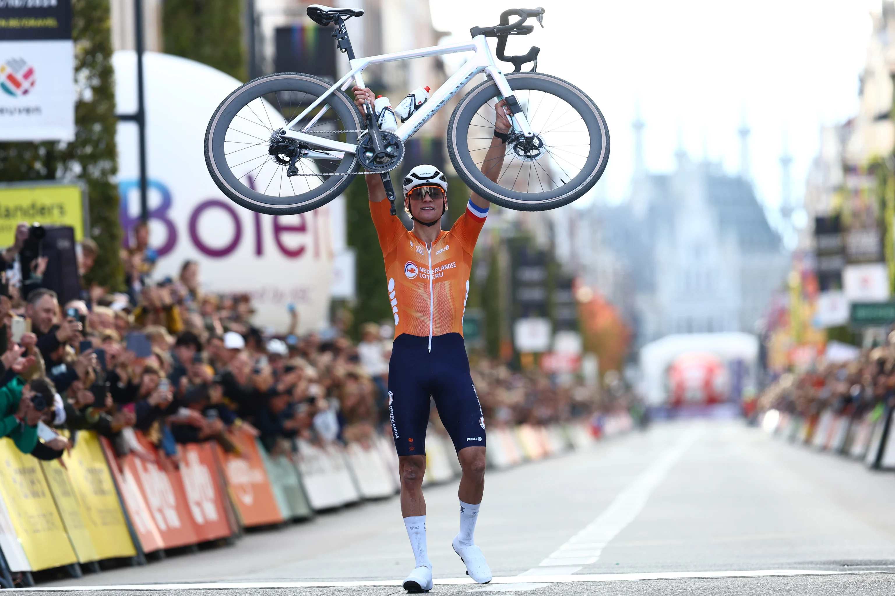 Dutch Mathieu Van Der Poel celebrates carrying his bike to cross the finish line at the men elite race at the UCI World Gravel Championships, Sunday 06 October 2024, in Leuven. BELGA PHOTO DAVID PINTENS