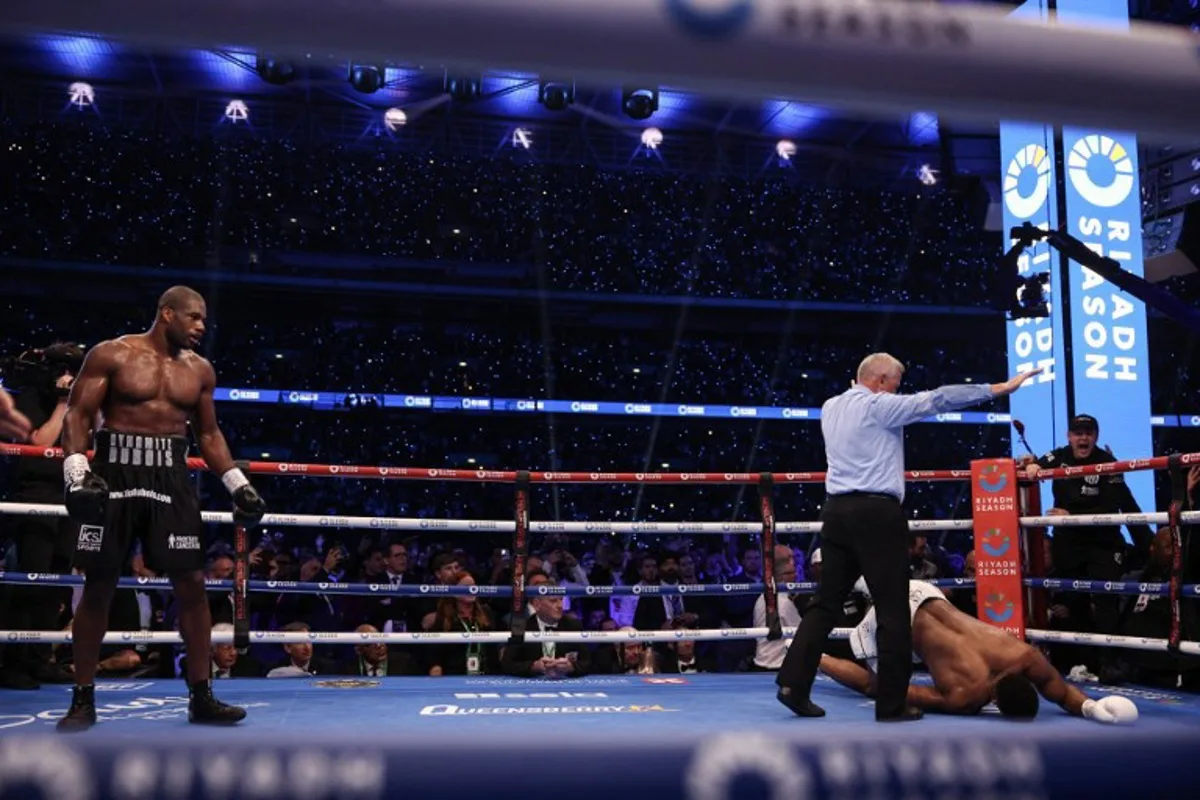 Britain's Anthony Joshua (R) is knocked to the ground by Britain's Daniel Dubois during their heavyweight boxing match for the IBF world title at Wembley Stadium in London on September 21, 2024.   Adrian Dennis / AFP