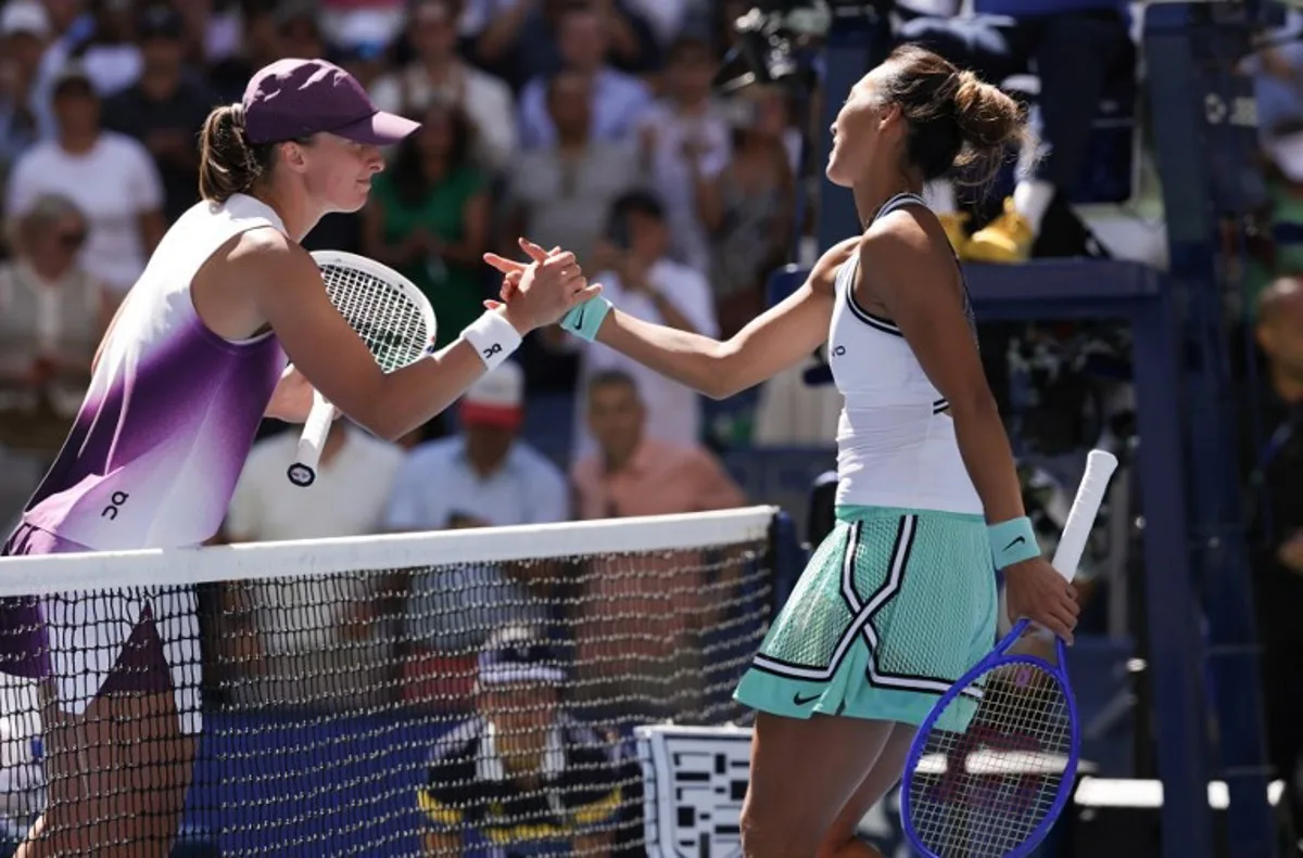 China's Qinwen Zheng (R) shakes hands with Poland's Iga Swiatek after defeating her in their women's singles round of 16 tennis match on day nine of the US Open tennis tournament at the USTA Billie Jean King National Tennis Center in New York on September 7, 2026.  KENA BETANCUR / AFP