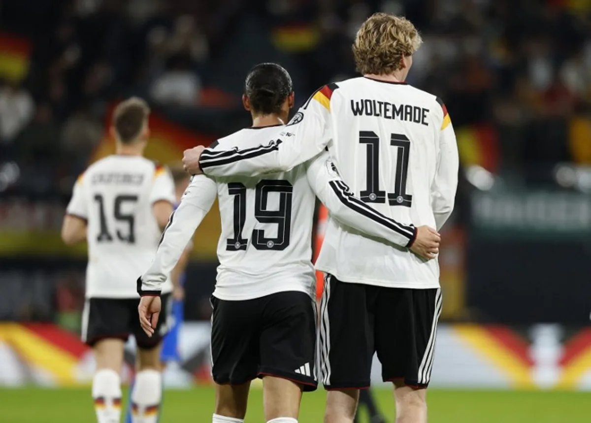 Germany's midfielder #19 Leroy Sane (L) celebrates with Germany's forward #11 Nick Woltemade scoring his team's third goal during the FIFA World Cup 2026 European qualification Group A football match between Germany and Slovakia, at the Red Bull Arena in Leipzig, eastern Germany on November 17, 2025.  Odd ANDERSEN / AFP