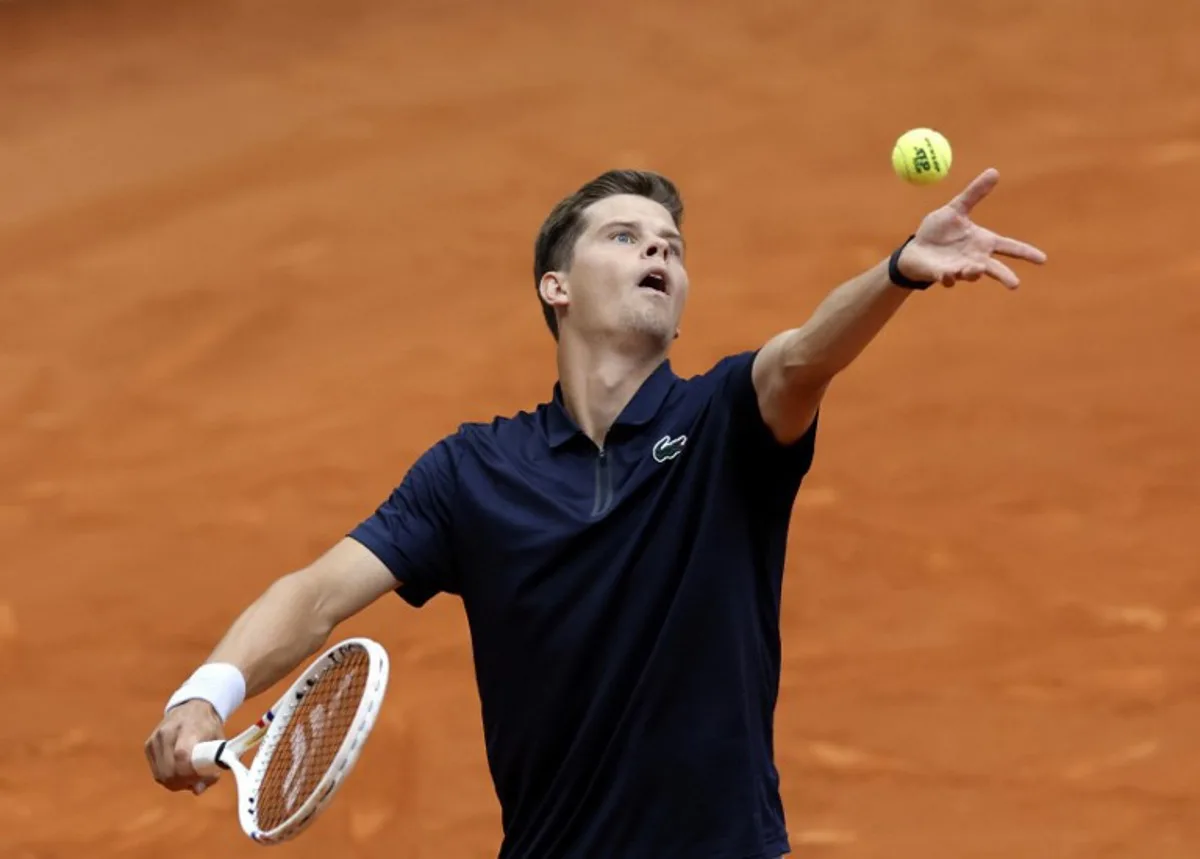 Belgium's Alexander Blockx serves to Canada's Felix Auger-Aliassime during their 2026 ATP Tour Madrid Open tennis tournament third round singles match at the Caja Magica in Madrid, on April 27, 2026.   OSCAR DEL POZO / AFP