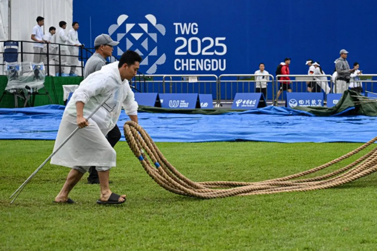 A staff member carries the ropes after the women's outdoor 500kg tug-of-war gold medal match on a rainy day during the 2025 World Games at the Dong'an Lake Sports Park Central Square in Chengdu, in China's southwestern Sichuan province on August 10, 2025. Jade GAO / AFP