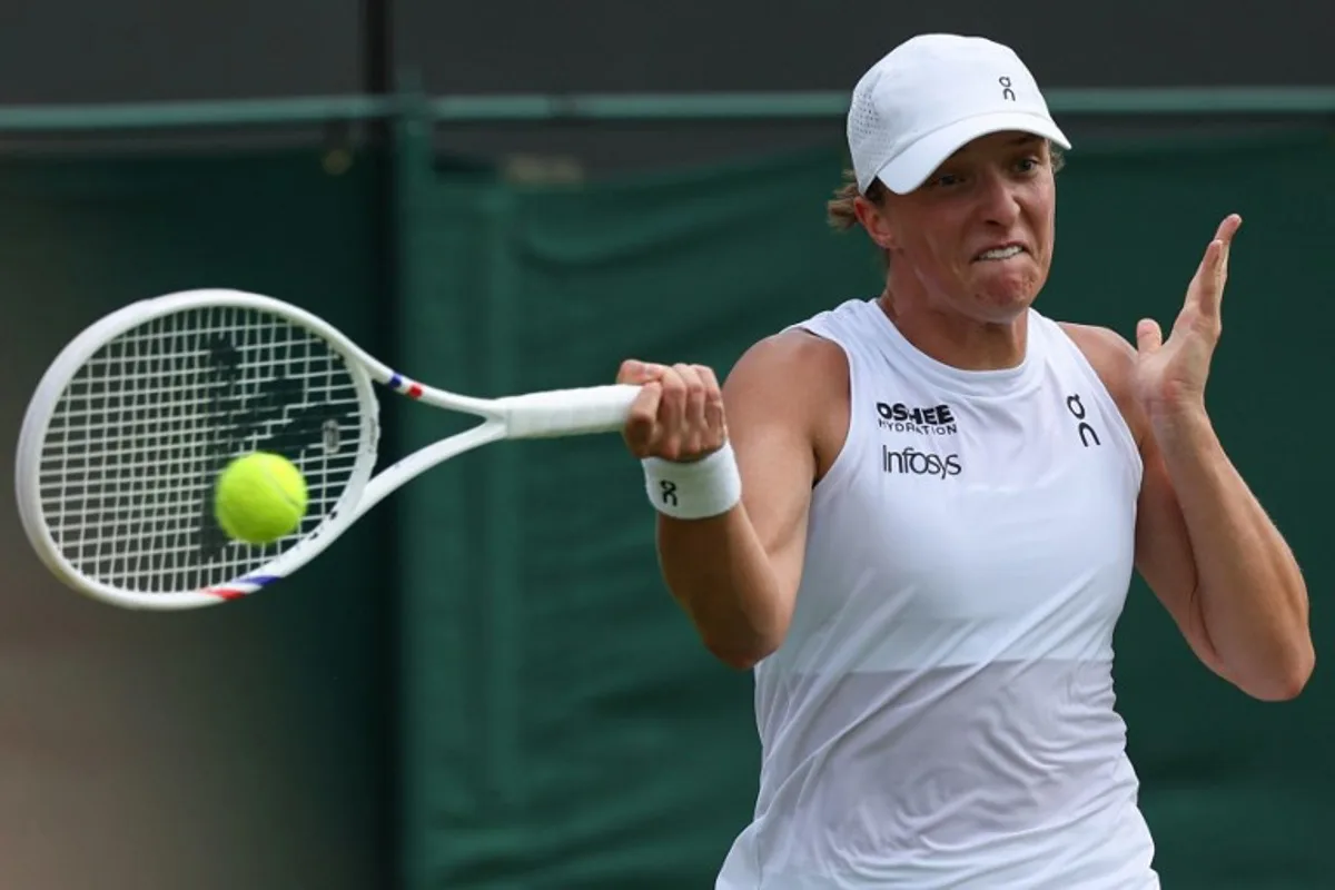 Poland's Iga Swiatek plays a forehand return to Russia's Polina Kudermetova during their women's singles first round tennis match on the second day of the 2025 Wimbledon Championships at The All England Lawn Tennis and Croquet Club in Wimbledon, southwest London, on July 1, 2025. Adrian Dennis / AFP