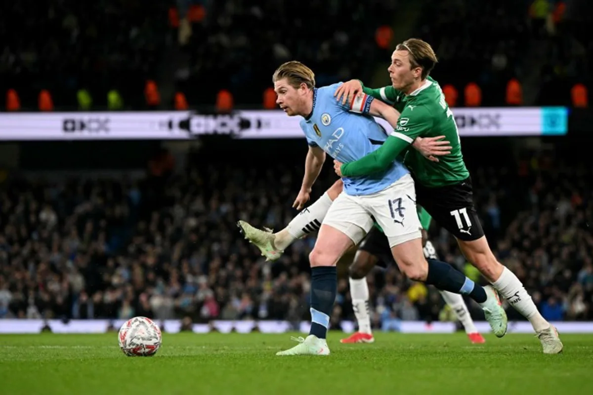 Plymouth's English midfielder #11 Callum Wright battles for the ball with Manchester City's Belgian midfielder #17 Kevin De Bruyne during the English FA Cup fifth round football match between Manchester City and Plymouth Argyle at the Etihad Stadium in Manchester, north west England, on March 1, 2025.  Oli SCARFF / AFP