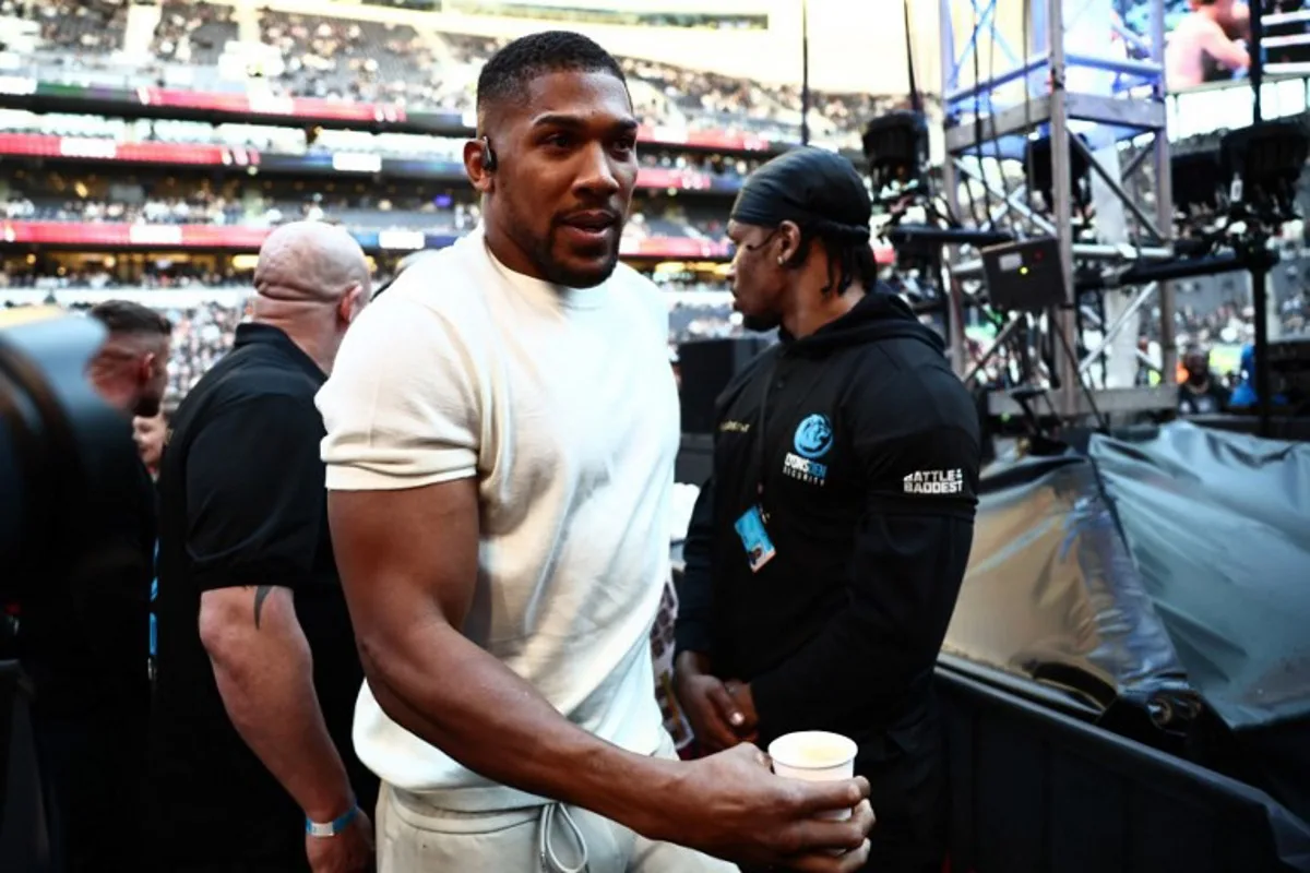 British boxer Anthony Joshua is seen ringside ahead of the heavyweight fight between Britain's Tyson Fury and Russia's Arslanbek Makhmudov at the Tottenham Hotspur stadium in London on April 11, 2026.  Henry NICHOLLS / AFP