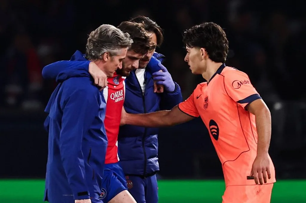 Barcelona's Spanish defender #12 Xavi Espart (R) comforts PSG's Georgian forward #07 Khvicha Kvaratskhelia leaving the pitch after sustaining an injury during the UEFA Champions League first round day 3 football match between Paris Saint Germain (PSG) and FC Barcelona at the Parc de Princes stadium in Paris on October 20, 2026. FRANCK FIFE / AFP