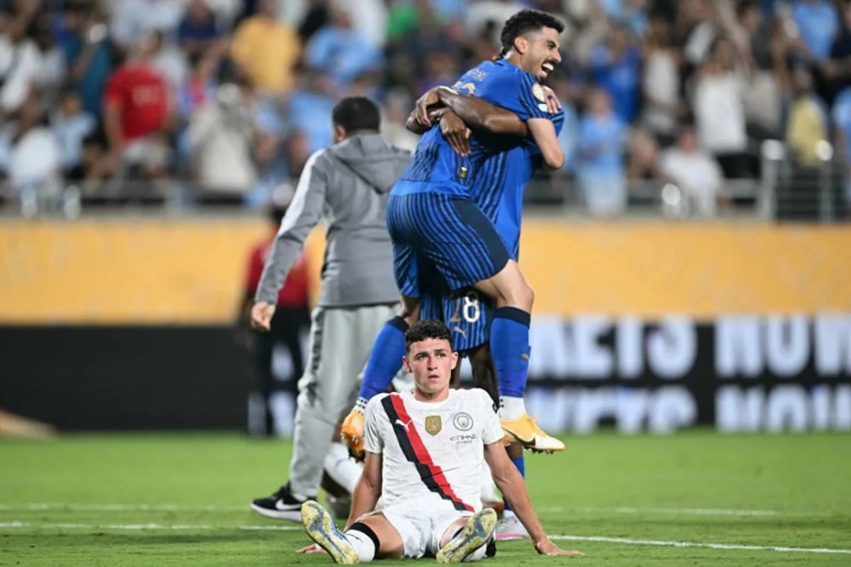 Manchester City's English midfielder #47 Phil Foden reacts while players of Al-Hilal celebrate at the end of the FIFA Club World Cup 2025 round of 16 football match between England's Manchester City and Saudi's Al-Hilal at the Camping World stadium in Orlando on June 30, 2025. PATRICIA DE MELO MOREIRA / AFP