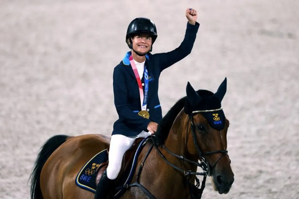 (L-R) Gold medalist, Sweden Malin Baryard-Johnsson parades with Indiana after the medal ceremony of the equestrian's jumping team during the Tokyo 2020 Olympic Games at the Equestrian Park in Tokyo on August 7, 2021.  Behrouz MEHRI / AFP