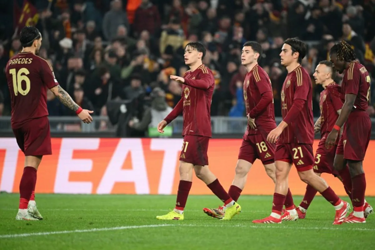 Roma's Italian midfielder #61 Niccolo Pisilli celebrates with teammates scoring his team's third goal during the UEFA Europa League knockout round play-off 2nd leg football match between AS Roma and FC Porto at the Olympic stadium in Rome, on February 20, 2025.  Alberto PIZZOLI / AFP