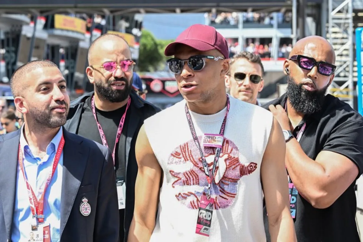 French footballer Kylian Mbappe (2R) walks in the pit lane ahead of the Formula One Monaco Grand Prix at the Circuit de Monaco, on May 25, 2025. Gabriel BOUYS / POOL / AFP