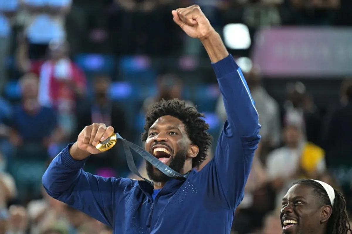 Gold medallist USA's #11 Joel Embiid celebrates on the podium after the men's Gold Medal basketball match between France and USA during the Paris 2024 Olympic Games at the Bercy  Arena in Paris on August 10, 2024.  Damien MEYER / AFP