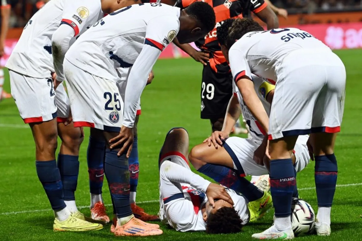 Paris Saint-Germain's French midfielder #14 Desire Doue (C) reacts in pain after suffering an injury during the French L1 football match between FC Lorient and Paris Saint-Germain (PSG) at the Stade du Moustoir in Lorient, western France, on October 29, 2025.  JEAN-FRANCOIS MONIER / AFP