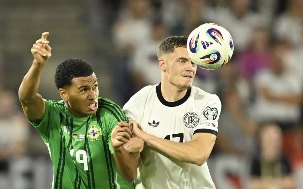 Germany's midfielder #17 Florian Wirtz (R) and Northern Ireland's defender #19 Shea Charles vie for the ball during the 2026 World Cup qualifiers Europe zone group A football match between Germany and Northern Ireland on September 7, 2025 in Cologne, western Germany. INA FASSBENDER / AFP