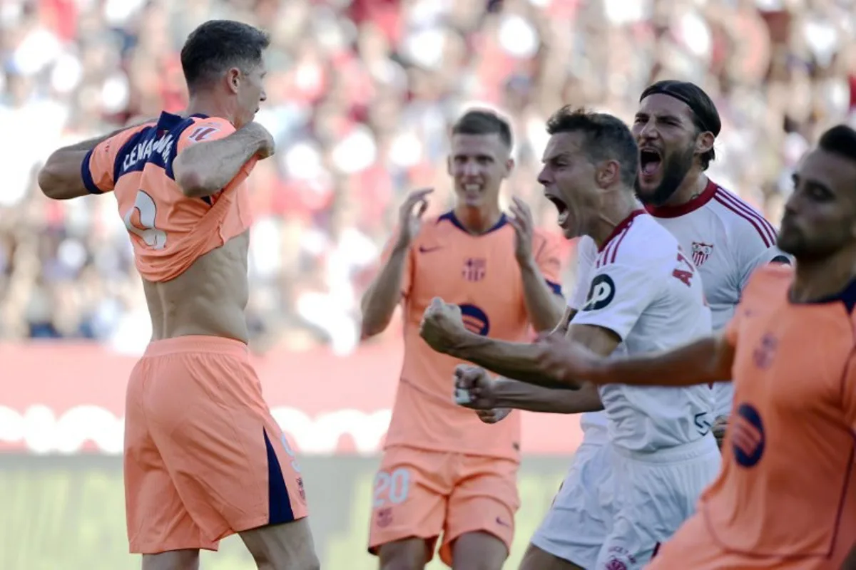 Barcelona's Polish forward #09 Robert Lewandowski (L) reacts to missing a penalty kick during the Spanish league football match between Sevilla FC and FC Barcelona at Ramon Sanchez Pizjuan Stadium in Seville on October 5, 2025.  CRISTINA QUICLER / AFP