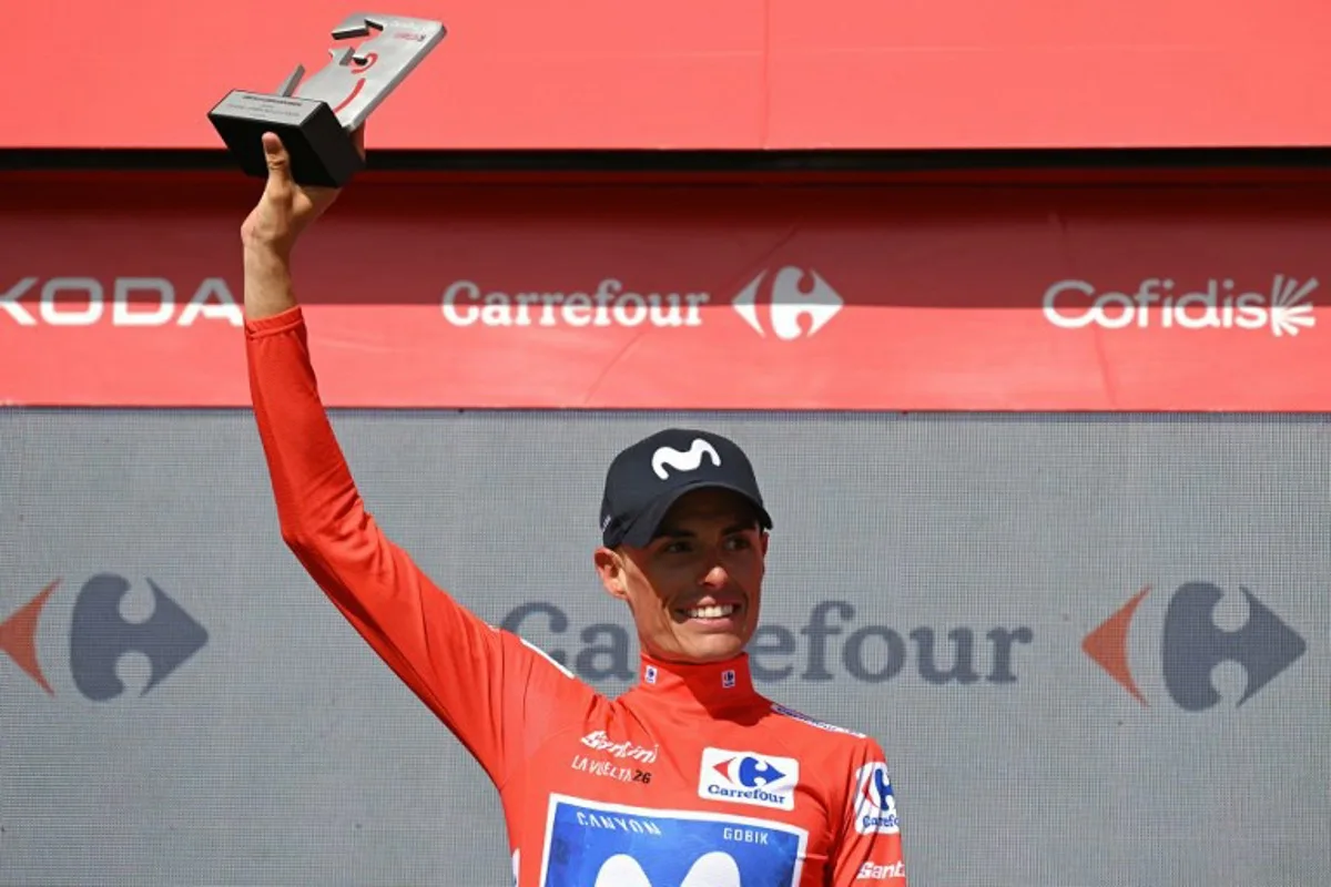 Team Movistar's Spanish rider Enric Mas celebrates on the podium retaining the overall ranking leader's red jersey after 16th stage of the Vuelta a Espana 2026 cycling tour, a 181,1 km race between Cortegana and the Monastery of Santa Maria de la Rabida in Palos de la Frontera, on September 8, 2026. JORGE GUERRERO / AFP