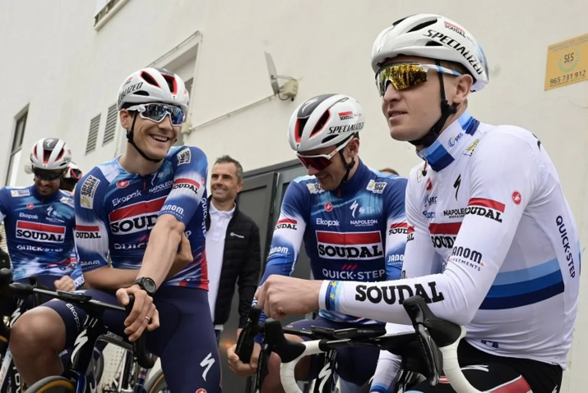 Team Soudal Quick-Step cyclist Tim Merlier of Belgium (R) talks with teammeates before a training session at Calpe, near Alicante, eastern Spain, on January 09, 2025.  JOSE JORDAN / STR / AFP