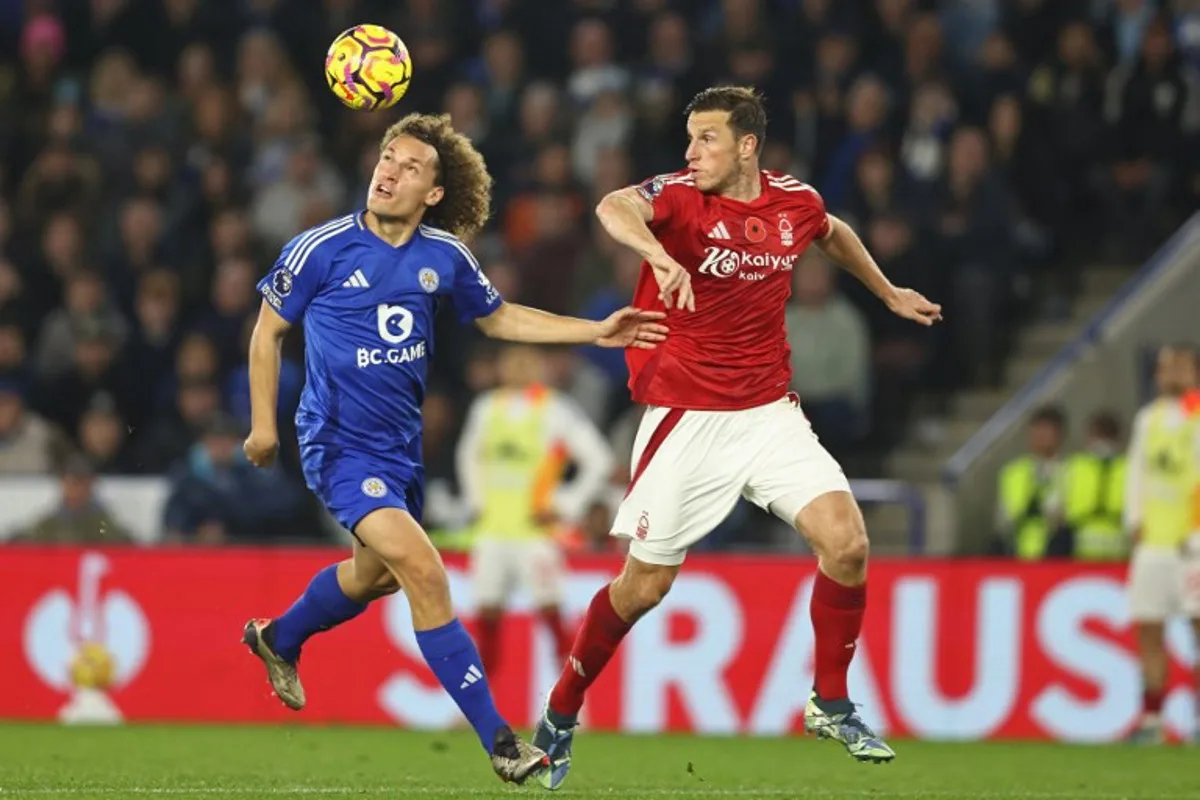 Leicester City's Belgian defender #03 Wout Faes (L) heads the ball into the path of Nottingham Forest's New Zealand striker #11 Chris Wood (R) before he scores their third goal during the English Premier League football match between Leicester City and Nottingham Forest at King Power Stadium in Leicester, central England on October 25, 2024.  Darren Staples / AFP