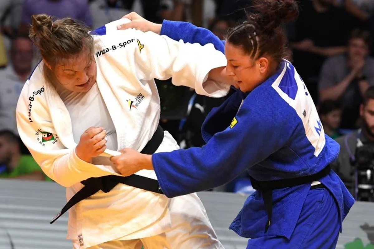 Germany's Anna-Monta Olek (Blue) and Belgium's Gabrielle Bouvier (White) compete in the women's +70 kg bout during the Judo's European Championships in Podgorica, on April 27, 2025. The tournament is taking place from April 23 to 27, 2025. SAVO PRELEVIC / AFP