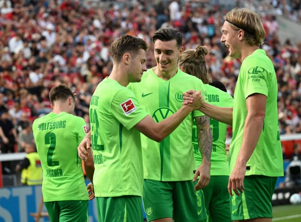 Wolfsburg's Swedish midfielder #32 Mattias Svanberg (L) celebrates scoring his team's third goal with Wolfsburg's Swiss defender #05 Cedric Zesiger and Wolfsburg's Belgian defender #03 Sebastiaan Bornauw (R) during the German first division Bundesliga football match between Bayer Leverkusen and VfL Wolfsburg in Leverkusen on September 22, 2024.  INA FASSBENDER / AFP