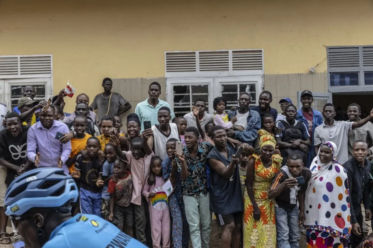 Residents gather to look at riders during the final stage of the 16h Tour du Rwanda on 25 February 2024, in Kigali. Israel Premier Tech's British rider Joseph Blackmore, won the Tour of Rwanda which ended on Sunday in the capital Kigali.  Guillem Sartorio / AFP