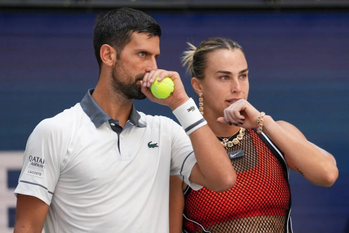Serbia's Novak Djokovic (L) and Belarus's Aryna Sabalenka (R) speak with each other during their mixed doubles tennis match against Czech Republic's Katerina Siniakova and Britain's Henry Patten during Fan Week as part of the 2026 US Open tennis tournament at the USTA Billie Jean King National Tennis Center in New York, on August 25, 2026.  TIMOTHY A. CLARY / AFP