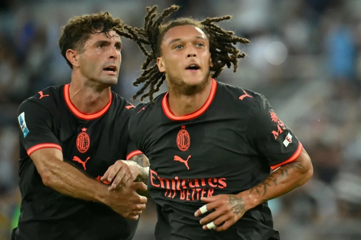 AC Milan's Belgian midfielder #22 Diego Moreira (R) celebrates after scoring Milan's second goal during the Italian Serie A football match between Lazio and AC Milan at the Olympic Stadium in Rome on September 12, 2026. Alberto PIZZOLI / AFP
