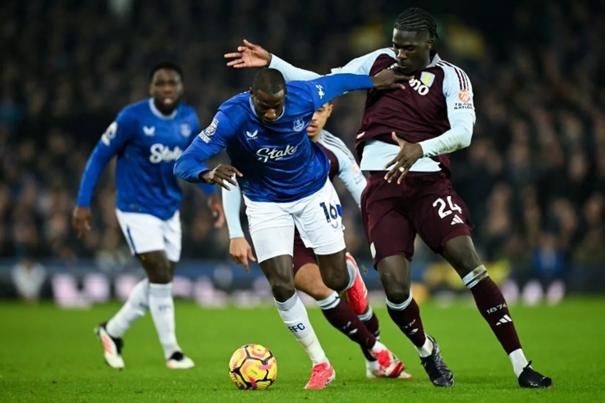 Everton's French midfielder #16 Abdoulaye Doucoure (L) fights for the ball with Aston Villa's Belgian defender #24 Amadou Onana during the English Premier League football match between Everton and Aston Villa at Goodison Park in Liverpool, north west England on January 15, 2025.  Oli SCARFF / AFP