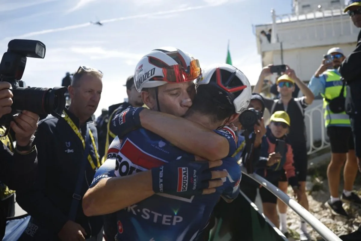 Soudal Quick-Step team's French rider Valentin Paret-Peintre (R) celebrates with teammate Soudal Quick-Step team's Belgian rider Ilan Van Wilder (C) after crossing the finish line to win the 16th stage of the 112th edition of the Tour de France cycling race, 171.5 km between Montpellier and Mont Ventoux, southern France, on July 22, 2025. MARTIN DIVISEK / POOL / AFP