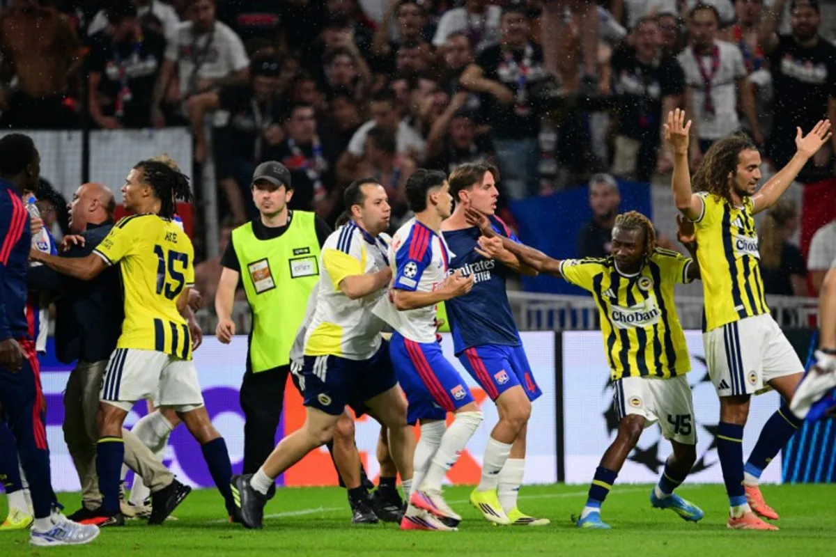 Fenerbahce's Malian forward #45 Nene Dorgeles (2R) tried to seperate Fenerbahce's French midfielder #06 Matteo Guendouzi (R) and Lyon's players after the final whistle at the end of the UEFA Champions League qualifying playoff - second leg football match between Olympique Lyonnais (OL) and Fenerbahce SK at the Groupama Stadium in Decines-Charpieu, central-eastern France, on August 26, 2026.  Olivier CHASSIGNOLE / AFP
