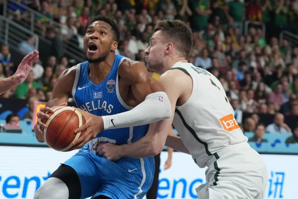 Greece's small forward #34 Giannis Antetokounmpo (L) vies with Lithuania's center #01 Marek Blazevic during the FIBA EuroBasket 2025 basketball quarter final match between Lithuania and Greece at the Arena Riga in Riga, Latvia, on September 9, 2025.  Gints Ivuskans / AFP