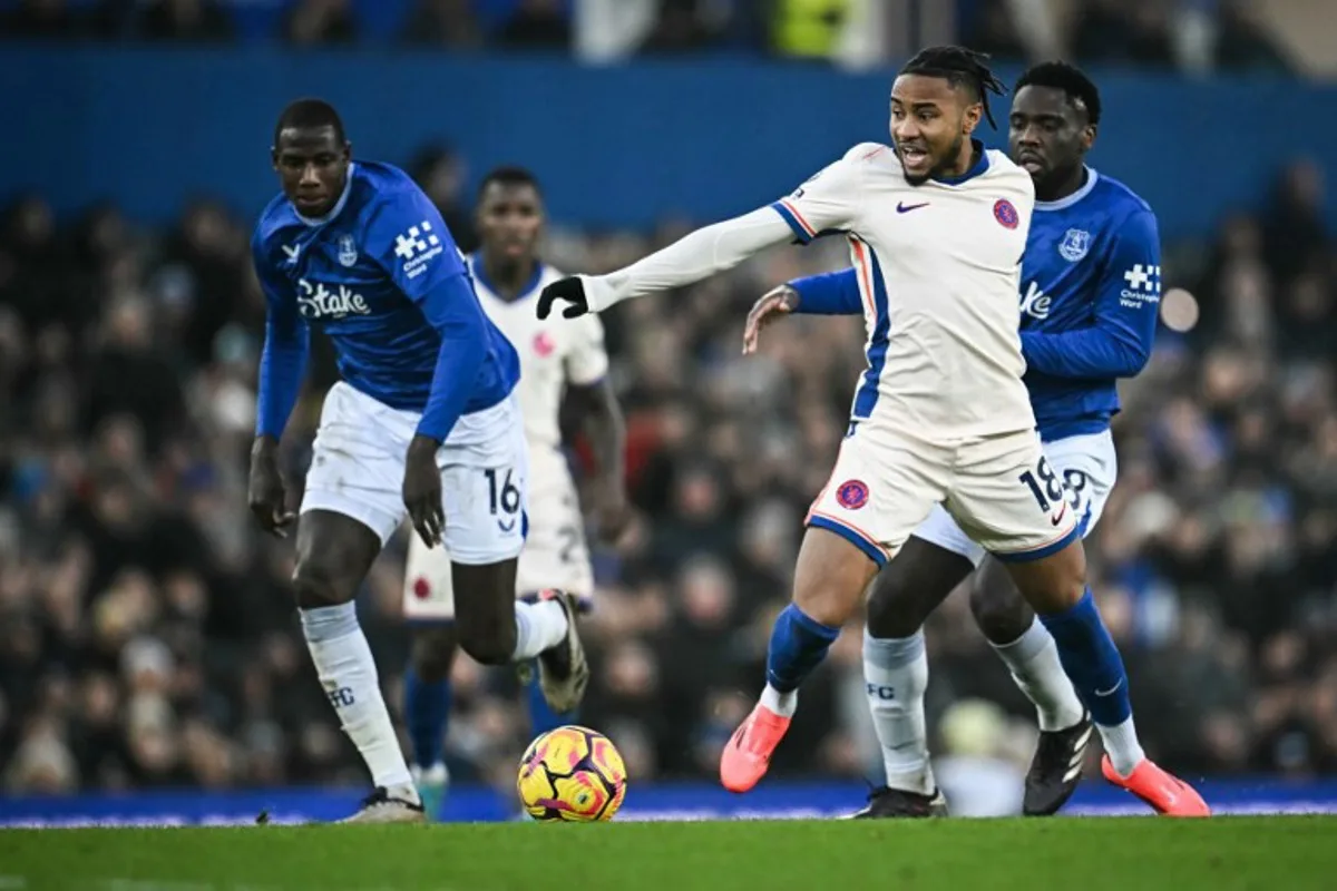 Chelsea's French striker #18 Christopher Nkunku (front R) fights for the ball with Everton's Belgian midfielder #08 Orel Mangala (rear R) during the English Premier League football match between Everton and Chelsea at Goodison Park in Liverpool, north west England on December 22, 2024.  Paul ELLIS / AFP