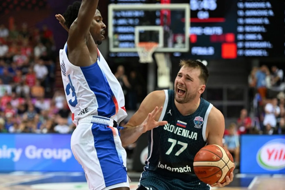 France's forward #34 Jaylen Hoard (L) and Slovenia's guard #77 Luka Doncic (R) vie during the FIBA EuroBasket 2025 Group D basketball match between France and Slovenia at the Spodek Arena in Katowice, Poland on August 30, 2025. Sergei GAPON / AFP