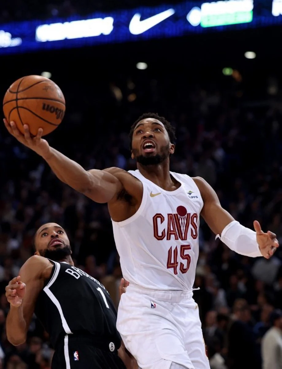 Cleveland Cavaliers' US Point Guard Donovan Mitchell (R) jumps to score in front of Brooklyn Nets' US Point Guard Mikal Bridges (L) during the NBA regular season basketball match between the Cleveland Cavaliers and the Brooklyn Nets at the Accor Arena in Paris on January 11, 2024.  Emmanuel Dunand / AFP