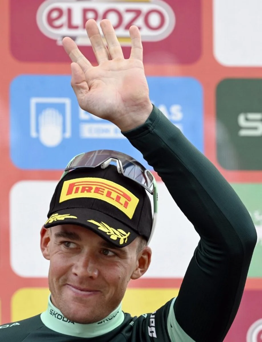 Team Lidl-Trek's Danish rider Mads Pedersen celebrates on the podium wearing the points ranking leader's green jersey after the 14th stage of the Vuelta a Espana cycling tour, a 135 km race between Aviles and La Farrapona in Somiedo, on September 6, 2025. Miguel RIOPA / AFP