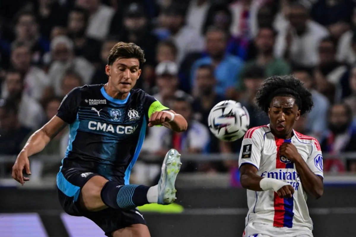Marseille's Argentinian defender #05 Leonardo Balerdi (L) fights for the ball with Lyon's Belgium forward #11 Malick Fofana during the French L1 football match between Olympique Lyonnais (OL) and Olympique Marseille (OM) at the Groupama Stadium in Decines-Charpieu, central-eastern France, on August 31, 2025. OLIVIER CHASSIGNOLE / AFP