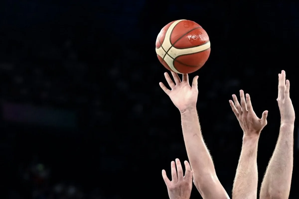 Players reach for the ball during the men's quarterfinal basketball match between Serbia and Australia during the Paris 2024 Olympic Games at the Bercy  Arena in Paris on August 6, 2024.  Aris MESSINIS / AFP