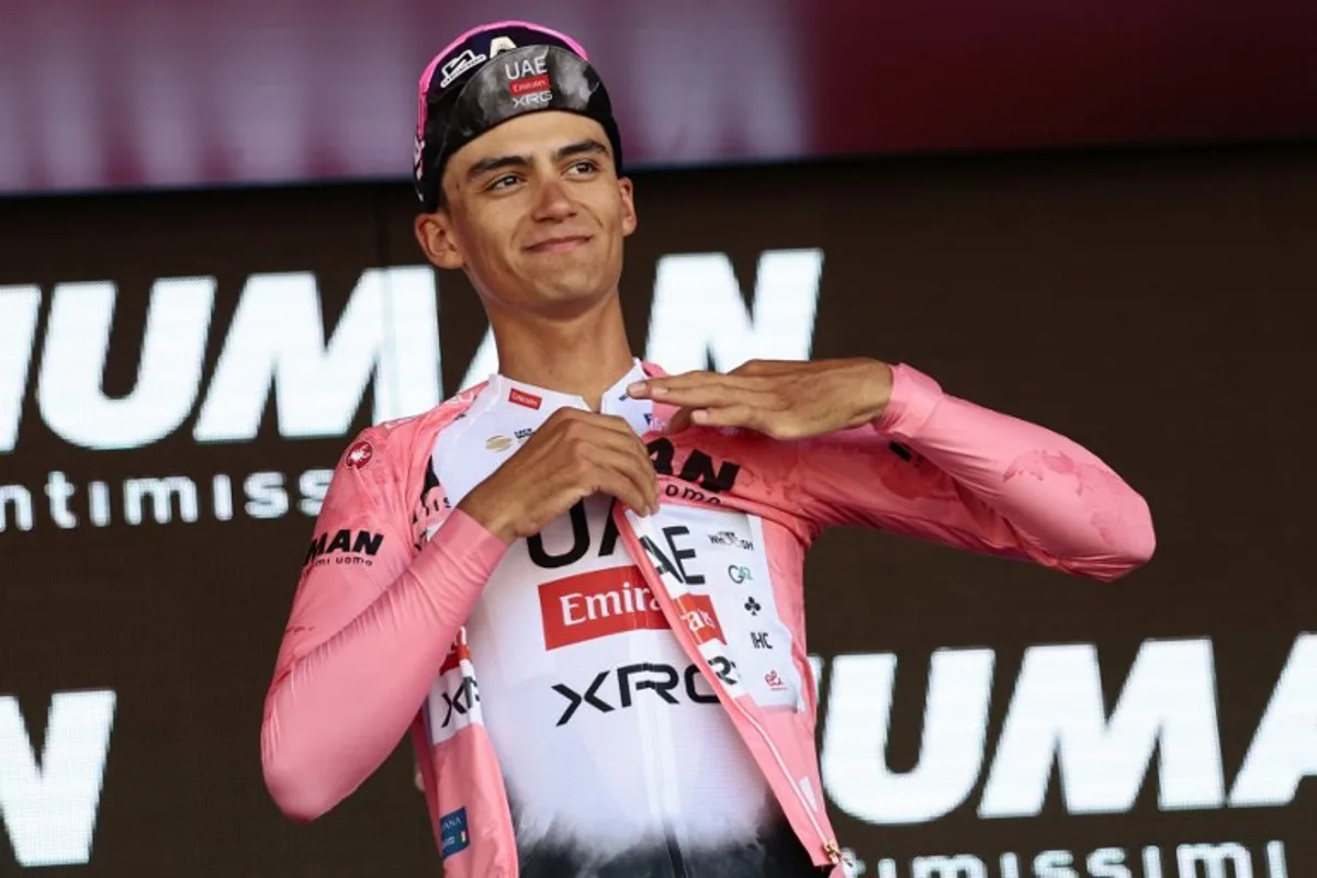 UAE Team Emirates XRG's Mexican rider Isaac Del Toro puts on the pink jersey of overall leader (Maglia Rosa) on the podium after 18th stage of the 108th Giro d'Italia cycling race of 144kms from Morbegno to Cesano Maderno on May 29, 2025. Luca Bettini / AFP