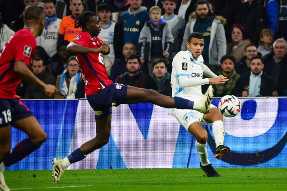 Marseille's English forward #10 Mason Greenwood (R) shoots the ball past Lille's Congolese midfielder #17 Ngal'ayel Mukau (2ndR) during the French L1 football match between Olympique de Marseille (OM) and Lille (LOSC) at Stade Velodrome in Marseille, southern France on December 14, 2024.  CLEMENT MAHOUDEAU / AFP