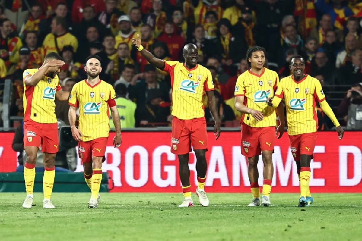 Lens' Saudi Arabian defender #23 Saud Abdulhamid (R) is congratulated after scoring his team's fourth goal during the French Cup semi-final football match between and RC Lens and Toulouse FC at the Stade Bollaert-Delelis in Lens, northern France on April 21, 2026.   Sameer AL-DOUMY / AFP