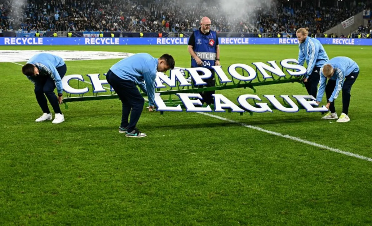 Volunteers place large letters of the Champions League logo on the pitch prior to the UEFA Champions League football match between SK Slovan Bratislava and Manchester City in Bratislava, Slovakia on October 1, 2024.  Joe Klamar / AFP