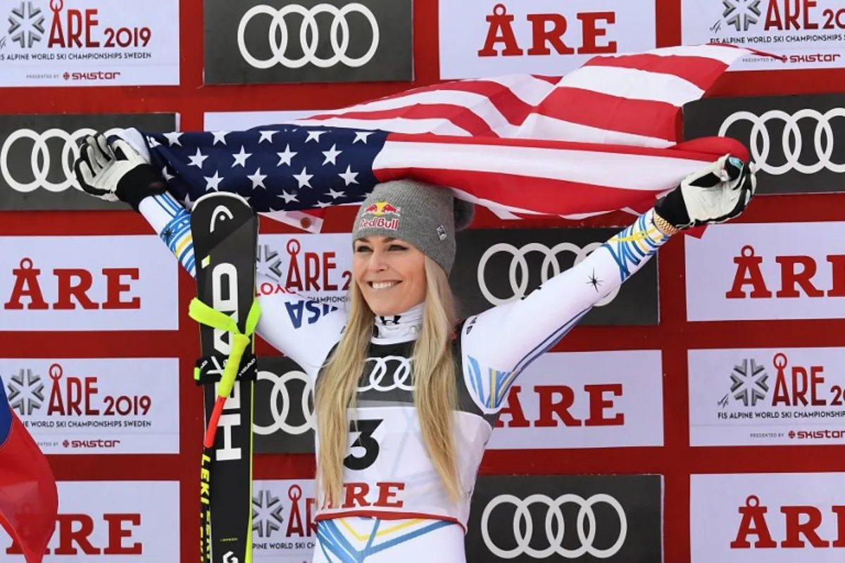 Third placed US Lindsey Vonn celebrates with an US flag during the flowers ceremony after the Women's Downhill event of the 2019 FIS Alpine Ski World Championships at the National Arena in Are, Sweden on February 10, 2019. Vonn, 34, who will retire from competitive skiing, is the most successful women skier of all time, with a record 20 World Cup titles to her name and 82 victories on the circuit.  Jonathan NACKSTRAND / AFP