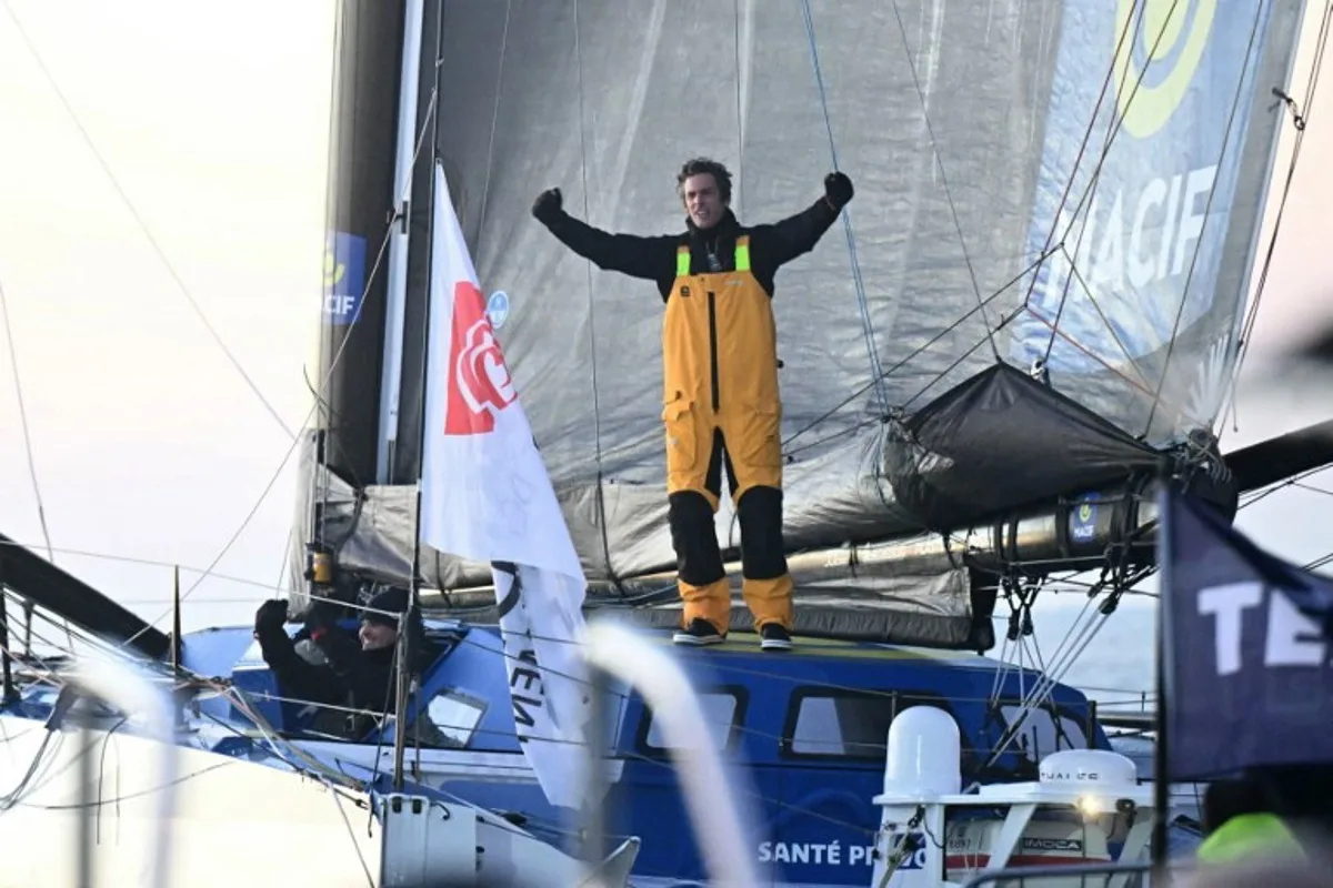 French skipper Charlie Dalin celebrates aboard his Imoca 60 monohull "Macif" after crossing the finish line of the 10th edition of the Vendee Globe around the world monohull solo sailing race, off the coast of Les Sables-d'Olonne, western France, early on January 14, 2025. French skipper Charlie Dalin won the round-the-world Vendee Globe race on January 14, finishing off Brittany in a record time of 64 days, 19 hours, 22 minutes and 49 seconds. LOIC VENANCE / AFP