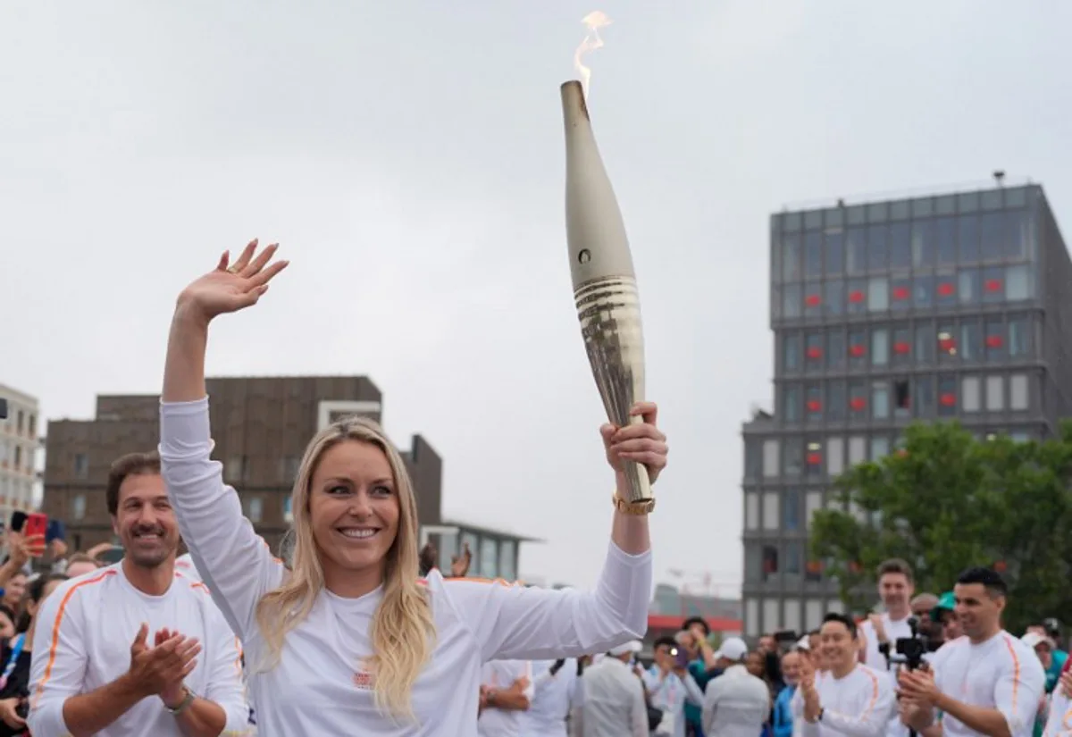 Former US skier Lindsey Vonn carries the Olympic torch in the Olympic Village in Paris on July 26, 2024, ahead of the Paris 2024 Olympic Games.   David Goldman / POOL / AFP