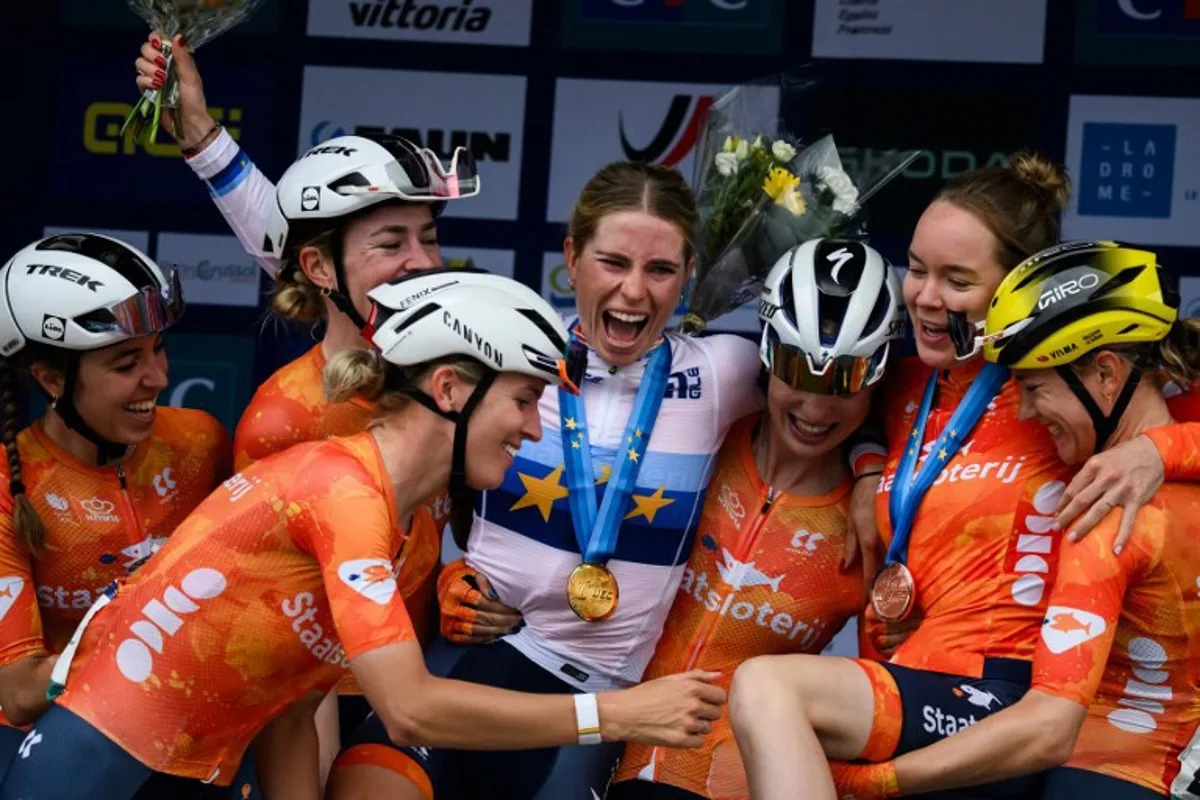 Dutch rider Demi Vollering celebrates with her teammates on the podium after winning the women 2025 UEC European road cycling championship, around Valence, on October 4, 2025. JEFF PACHOUD / AFP