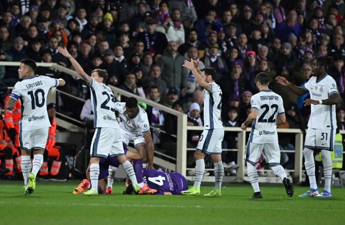 Players call for medics after Italian midfielder #04 Edoardo Bove (bottom, L) suddenly collapsed to the ground during the Serie A football match between Fiorentina and Inter Milan at the Artemio Franchi stadium in Florence on December 1, 2024.  TIZIANA FABI / AFP